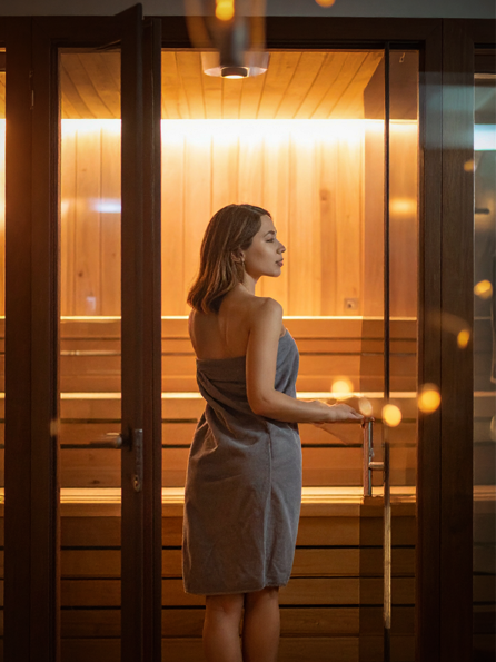 Woman entering the infrared sauna at Birch & Glen